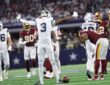 Dallas Cowboys wide receiver George Pickens spreads his arms wide and tilts his head back among Commanders defenders.
