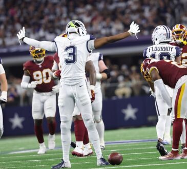 Dallas Cowboys wide receiver George Pickens spreads his arms wide and tilts his head back among Commanders defenders.
