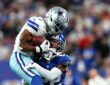Two Dallas Cowboys defenders wrap up New York Giants wide receiver Malik Nabers after a catch.