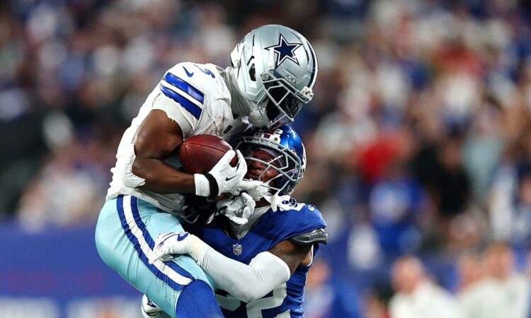 Two Dallas Cowboys defenders wrap up New York Giants wide receiver Malik Nabers after a catch.