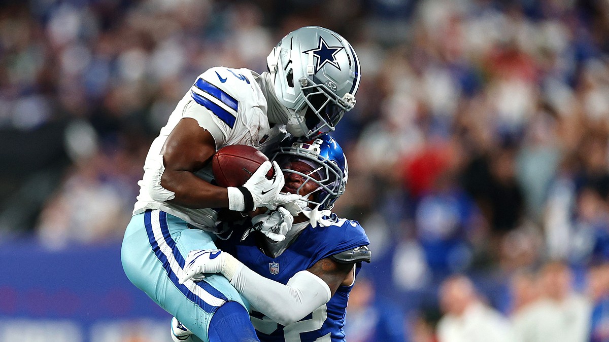 Two Dallas Cowboys defenders wrap up New York Giants wide receiver Malik Nabers after a catch.