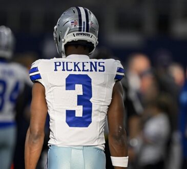 Dallas Cowboys wide receiver George Pickens stands with his back to the camera in his No. 3 jersey before kickoff.