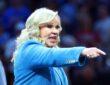 A woman in a blue blazer points toward the court during the women's national championship game.
