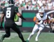 Dallas Cowboys running back Hunter Luepke cuts upfield with the ball as New York Jets safety Andre Cisco closes in.