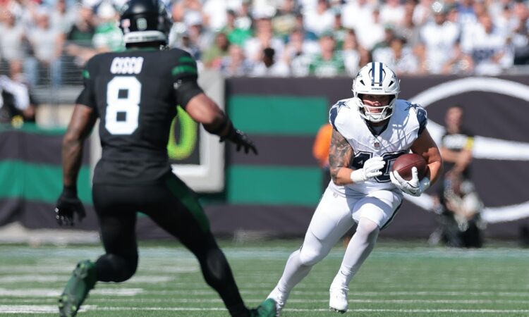 Dallas Cowboys running back Hunter Luepke cuts upfield with the ball as New York Jets safety Andre Cisco closes in.