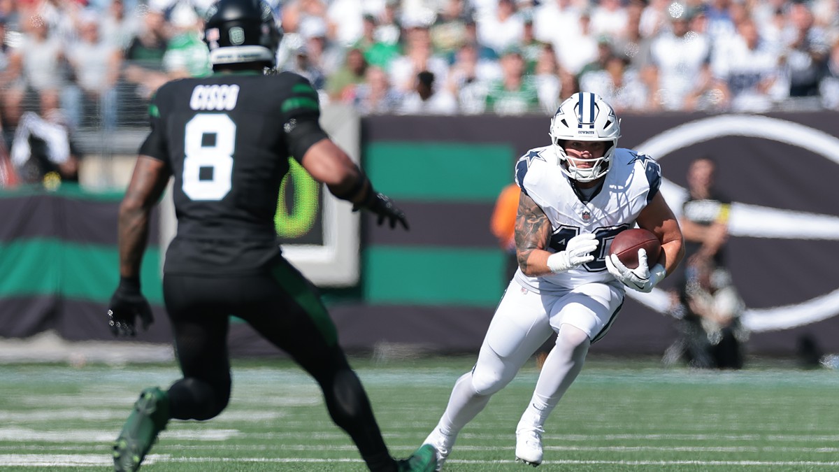Dallas Cowboys running back Hunter Luepke cuts upfield with the ball as New York Jets safety Andre Cisco closes in.