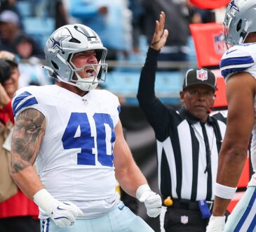 Dallas Cowboys running back Hunter Luepke yells with clenched fists as a teammate approaches and an official raises his arm.