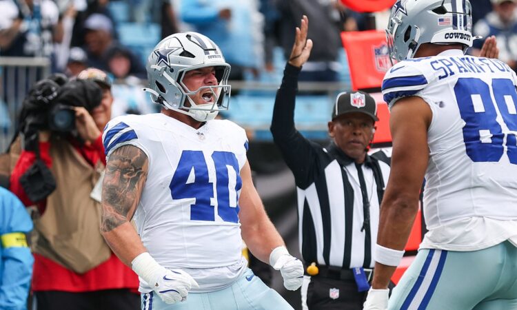 Dallas Cowboys running back Hunter Luepke yells with clenched fists as a teammate approaches and an official raises his arm.
