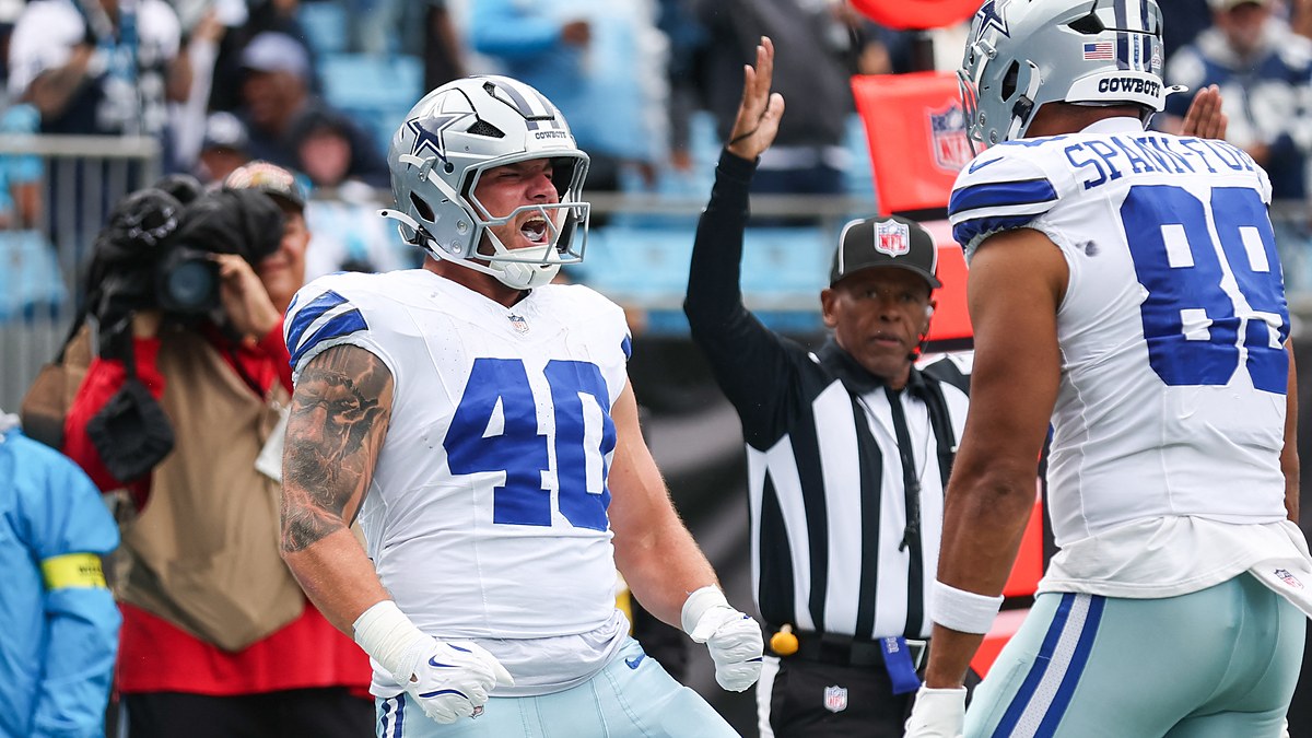 Dallas Cowboys running back Hunter Luepke yells with clenched fists as a teammate approaches and an official raises his arm.