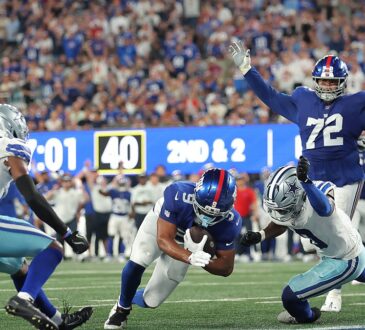 New York Giants tight end Isaiah Likely dives across the goal line as two Dallas Cowboys defenders close in.