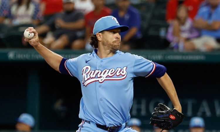 Texas Rangers starting pitcher Jacob deGrom winds up to deliver a pitch in a powder blue uniform.