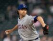 Texas Rangers starting pitcher Jacob deGrom winds up to throw a pitch in a gray road uniform and blue cap.