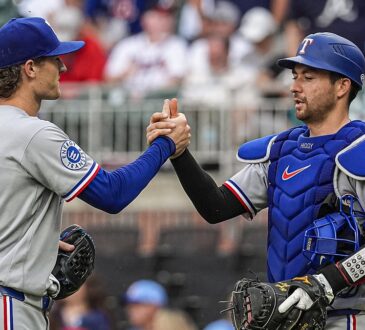 Texas Rangers pitcher Jacob Latz, No. 67, clasps hands with catcher Kyle Higashioka, No. 11, after a win.