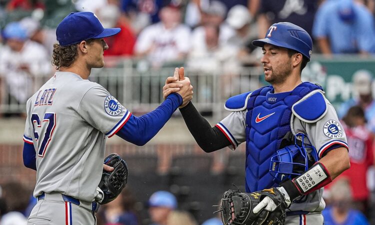 Texas Rangers pitcher Jacob Latz, No. 67, clasps hands with catcher Kyle Higashioka, No. 11, after a win.