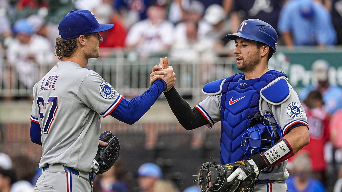 Texas Rangers pitcher Jacob Latz, No. 67, clasps hands with catcher Kyle Higashioka, No. 11, after a win.