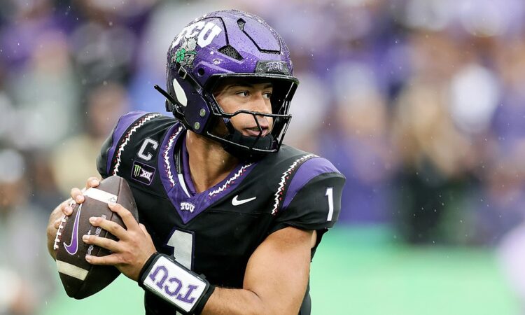 TCU quarterback Jaden Craig holds the ball at his chest and scans downfield during a rainy game.