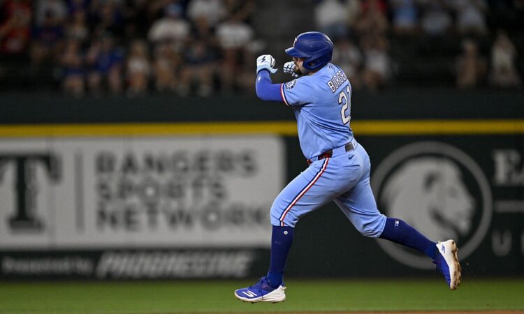 Texas Rangers first baseman Jake Burger pumps his fist as he rounds the bases after a home run at Globe Life Field.