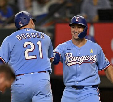 Texas Rangers first baseman Jake Burger and left fielder Wyatt Langford bump fists after Burger's second home run.