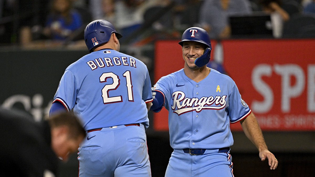 Texas Rangers first baseman Jake Burger and left fielder Wyatt Langford bump fists after Burger's second home run.