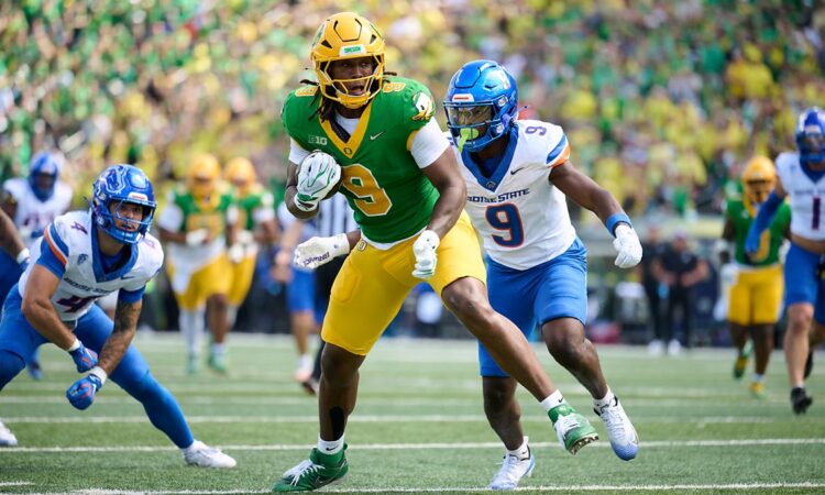 Oregon Ducks tight end Jamari Johnson runs with the ball as Boise State safety Derek Ganter Jr. pursues him.