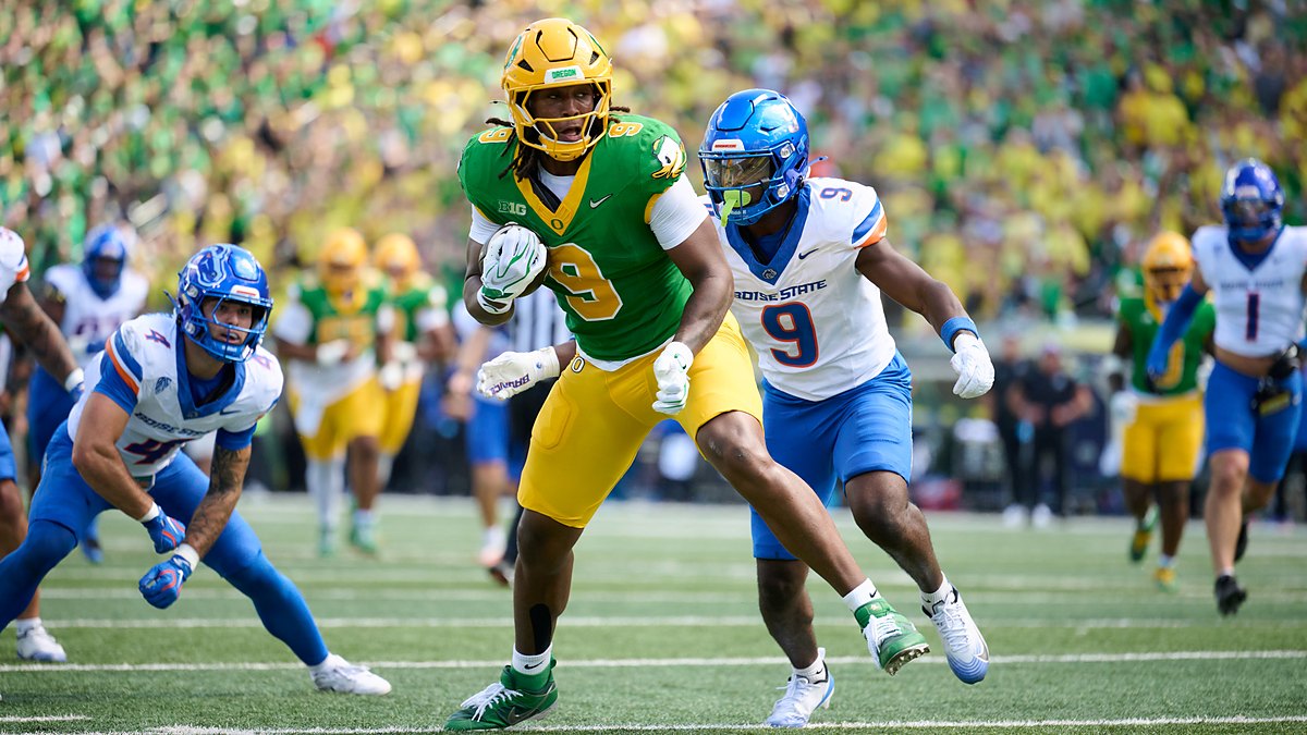 Oregon Ducks tight end Jamari Johnson runs with the ball as Boise State safety Derek Ganter Jr. pursues him.