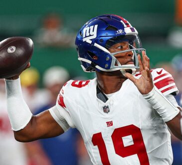 New York Giants quarterback Jameis Winston, No. 19, cocks the ball to throw with a rusher closing.