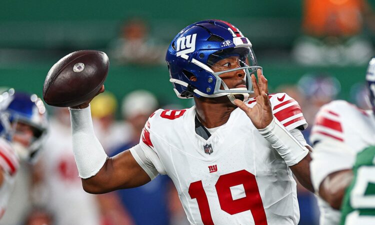 New York Giants quarterback Jameis Winston, No. 19, cocks the ball to throw with a rusher closing.