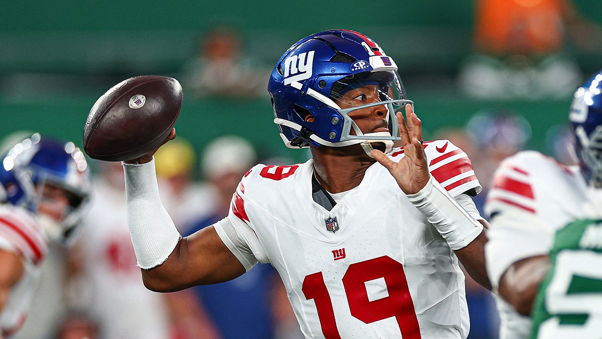 New York Giants quarterback Jameis Winston, No. 19, cocks the ball to throw with a rusher closing.
