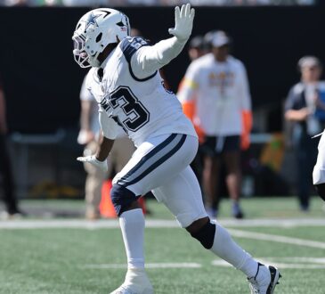 Dallas Cowboys defensive end James Houston raises a hand as he celebrates after a sack.