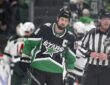 Stars captain Jamie Benn skates off the ice as Minnesota players celebrate behind him.