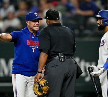 Texas Rangers shortstop Ezequiel Duran, No. 20, and manager Jared “Skip” Schumaker, No. 55, argue a called strike with home plate umpire Laz Diaz during the ninth inning against the New York Mets at Globe Life Field in Arlington, Texas, on Sept. 22, 2026.