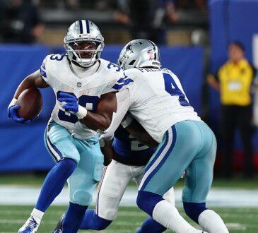 Cowboys running back Javonte Williams cuts upfield with the ball as a teammate blocks a Giants defender.