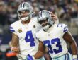 Dallas Cowboys running back Javonte Williams celebrates a touchdown with quarterback Dak Prescott, who pats his helmet.