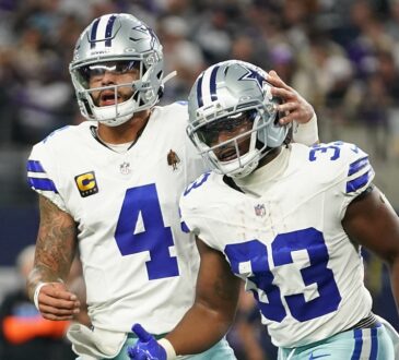 Dallas Cowboys running back Javonte Williams celebrates a touchdown with quarterback Dak Prescott, who pats his helmet.