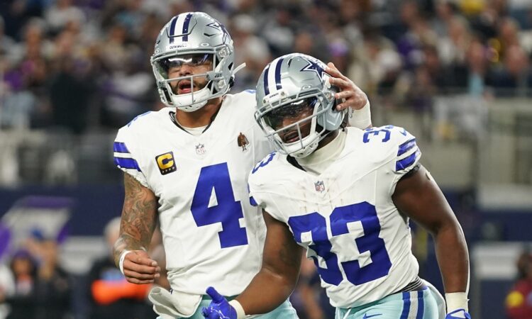 Dallas Cowboys running back Javonte Williams celebrates a touchdown with quarterback Dak Prescott, who pats his helmet.