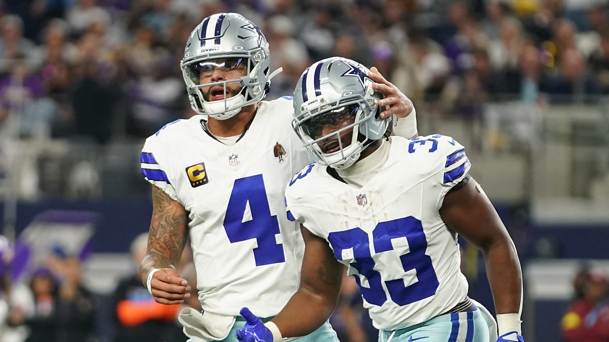 Dallas Cowboys running back Javonte Williams celebrates a touchdown with quarterback Dak Prescott, who pats his helmet.