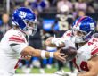 New York Giants quarterback Jaxson Dart extends the ball into running back Cam Skattebo's arms at the handoff.