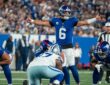 New York Giants quarterback Jaxson Dart spreads his arms to make a call at the line of scrimmage.