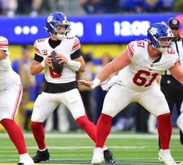 New York Giants quarterback Jaxson Dart holds the ball in the pocket as two offensive linemen block in front of him.