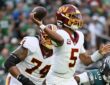 Commanders quarterback Jayden Daniels sets and releases a pass as an Eagles defender closes in from his right.
