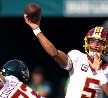 Commanders quarterback Jayden Daniels releases a pass over a lineman as an Eagles defender closes.