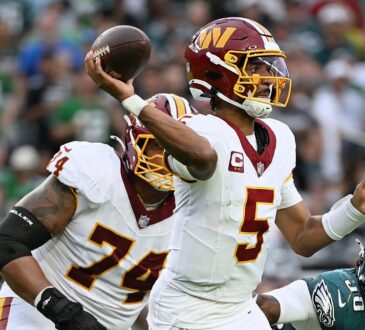 Commanders quarterback Jayden Daniels sets and releases a pass as an Eagles defender closes in from his right.