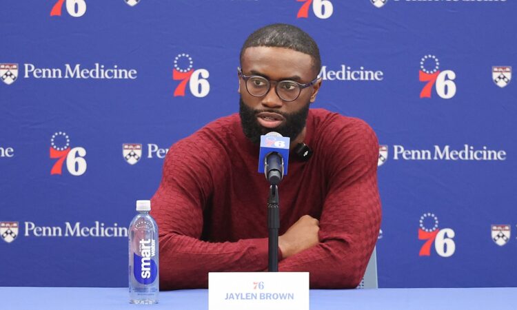 Philadelphia 76ers guard Jaylen Brown speaks at a table with a 76ers microphone and a nameplate reading Jaylen Brown.