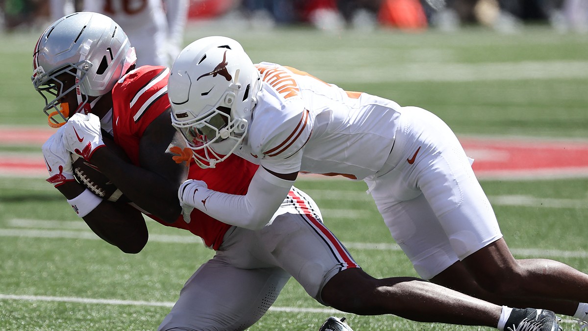 Ohio State Buckeyes wide receiver Jeremiah Smith secures the ball as Texas defensive back Malik Muhammad drags him down.