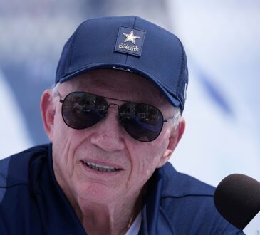 Dallas Cowboys owner Jerry Jones speaks into a microphone at the team's training camp opening press conference.