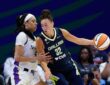 Dallas Wings forward Jessica Shepard extends the ball away as Los Angeles Sparks forward Dearica Hamby defends her.