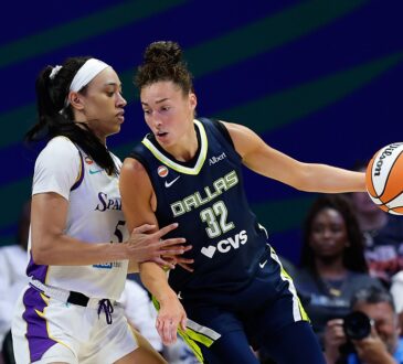 Dallas Wings forward Jessica Shepard extends the ball away as Los Angeles Sparks forward Dearica Hamby defends her.