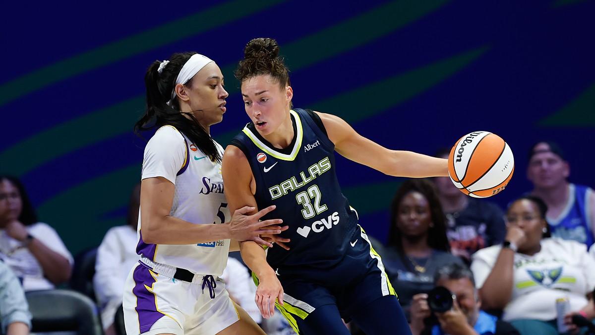 Dallas Wings forward Jessica Shepard extends the ball away as Los Angeles Sparks forward Dearica Hamby defends her.