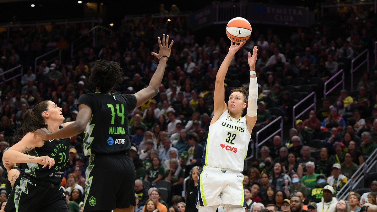 Dallas Wings forward Jessica Shepard releases a jump shot as Seattle Storm defenders reach to contest.