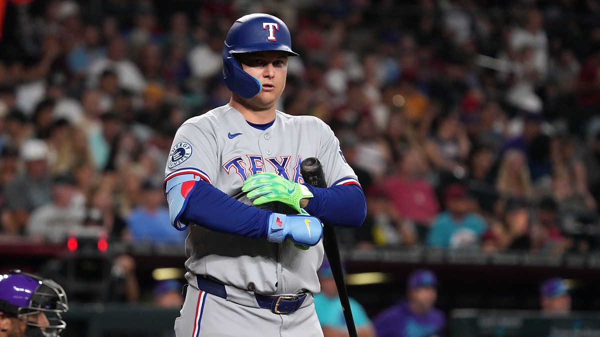 Rangers designated hitter Joc Pederson stands at the plate adjusting his batting gloves after a call.